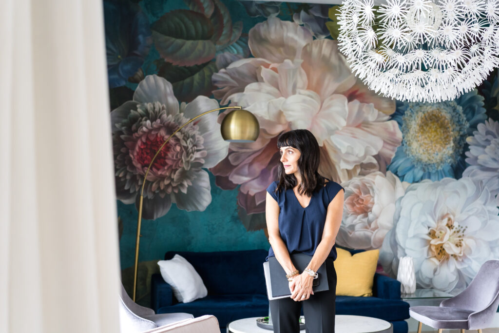 Austin, Texas Real estate business woman standing in front of a floral wall  