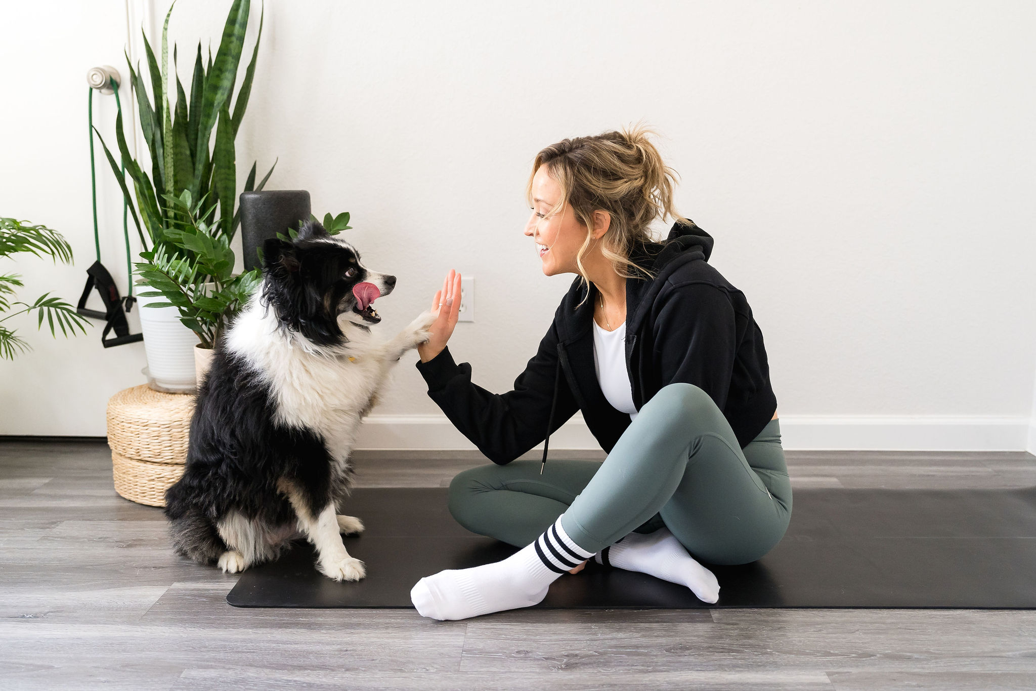 fitness instructor and wellness professional high fives with her dog