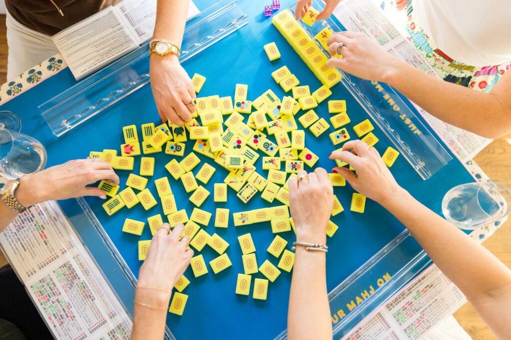 Mahjong players building their tile walls during a Mahj House Austin event.