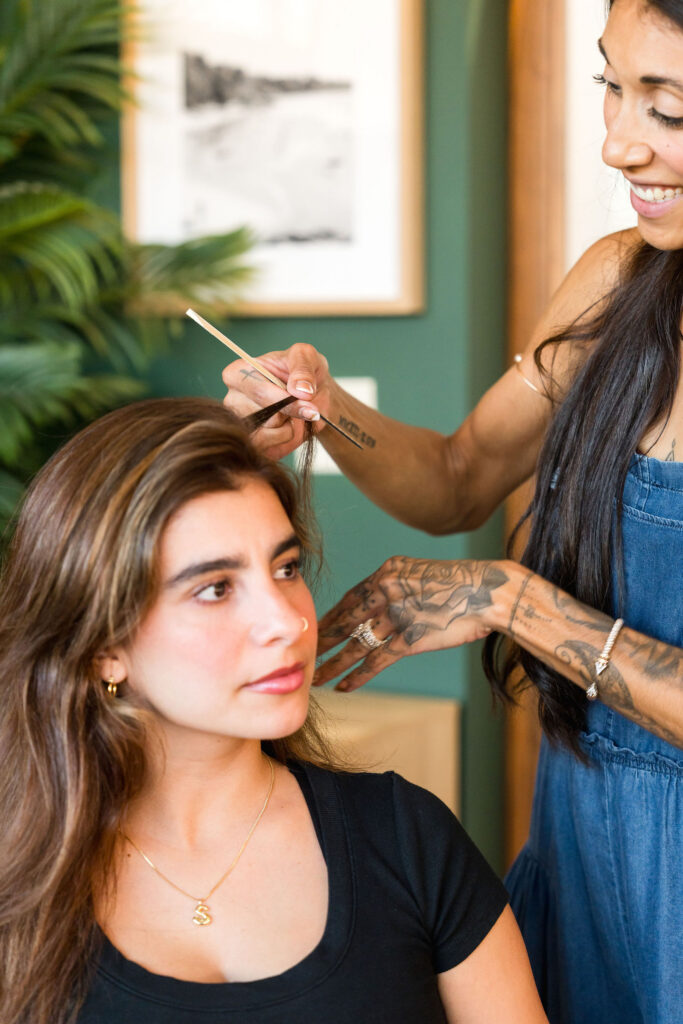 Hair stylist working on a client's part in the bright green private suite at Verano Luxe salon near Austin Texas