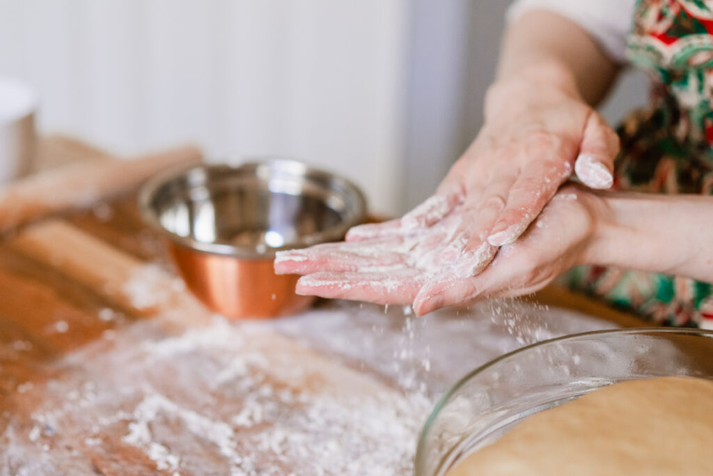 Woman rubbing her hands with dough on them