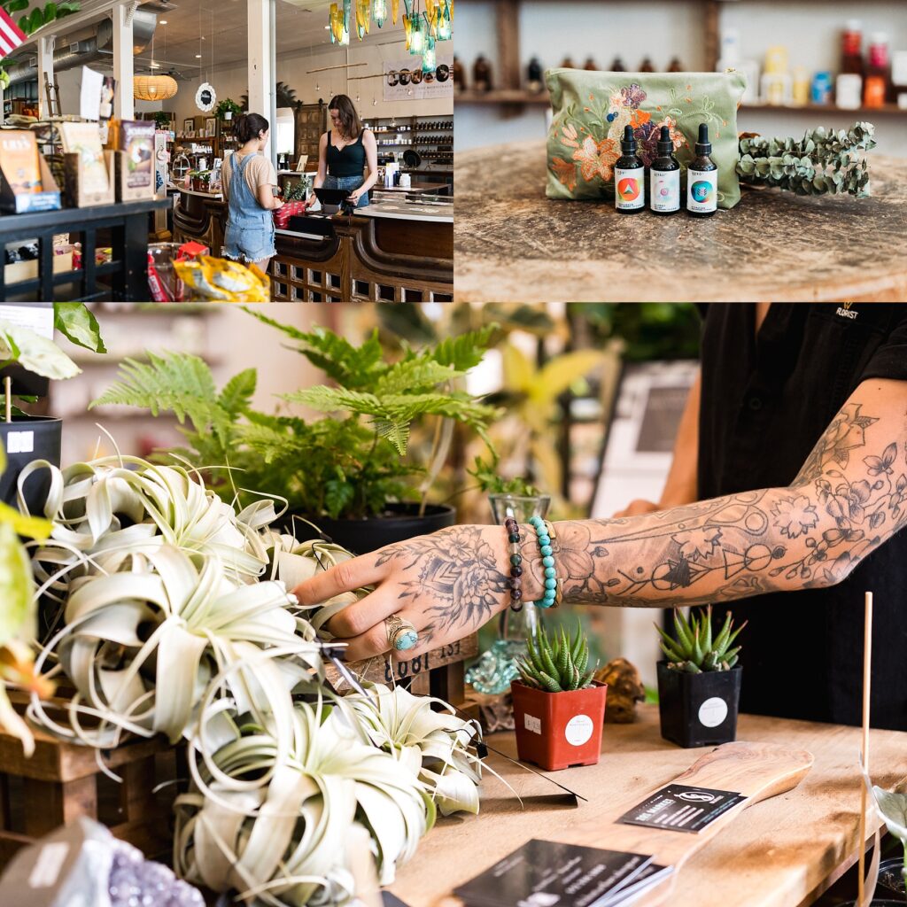 an employee with tattoos and turquoise jewelry rearranging plants on display, natural medicine on display with a small floral bag and eucalyptus 