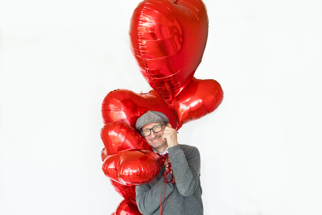 a man with red heart balloons
