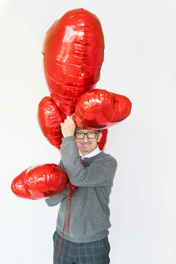a man with red heart balloons