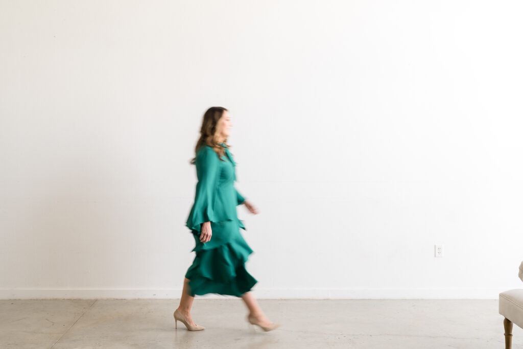 Woman in an emerald color dress walking